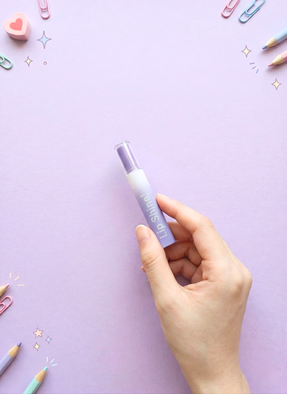 Hand holding a purple bottle labeled 'Curelle' on a light purple background with decorative items.