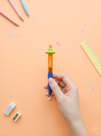 Hand holding a colorful pen with stationery items on a peach background