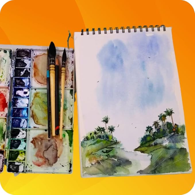 Artistic setup with watercolor paints, brushes, and a landscape painting on an orange background