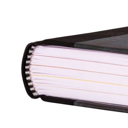 Close-up of a book with black binding and white pages on a white background