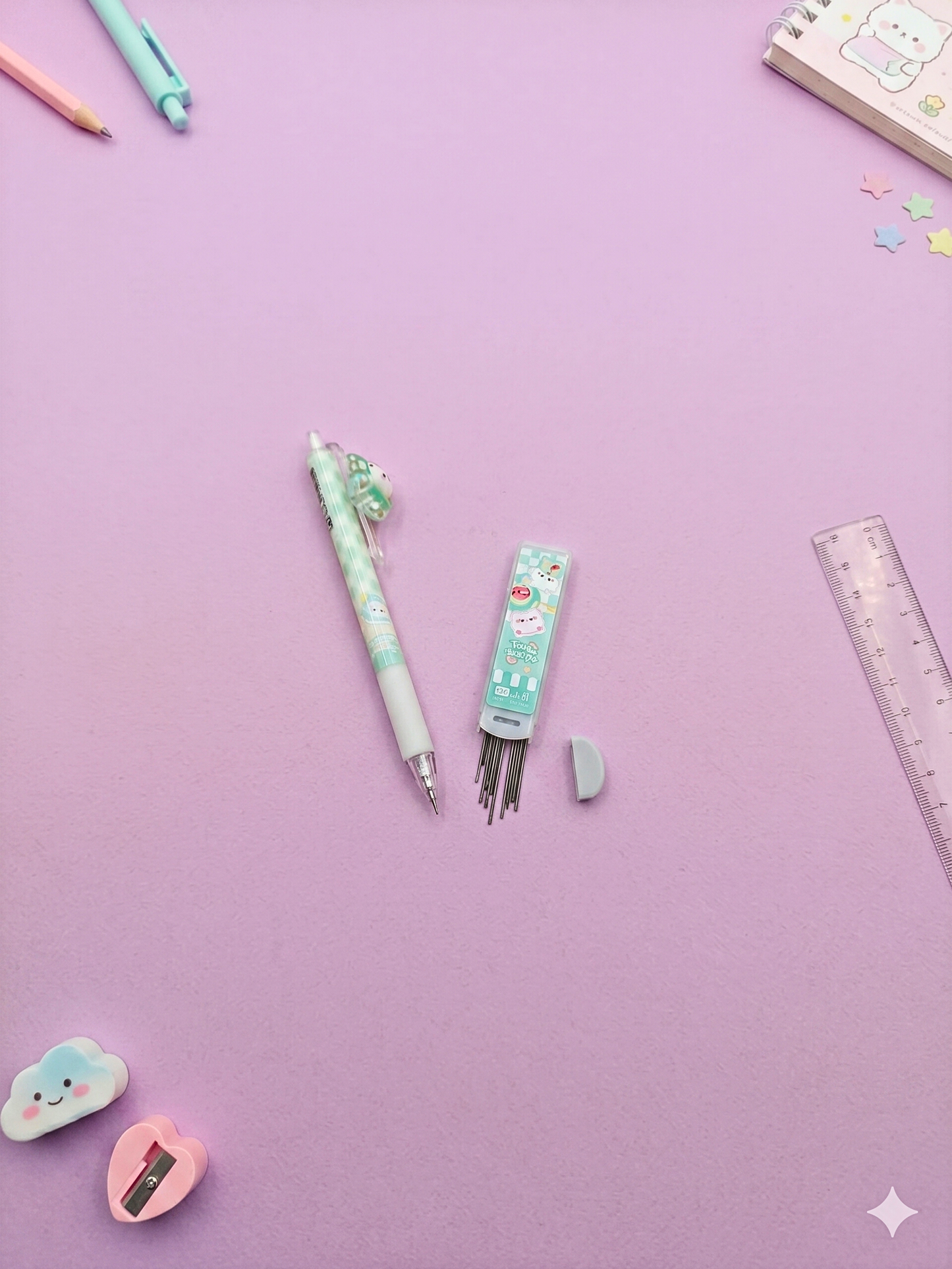 Stationery items including a pen, ink refills, and a ruler on a purple background