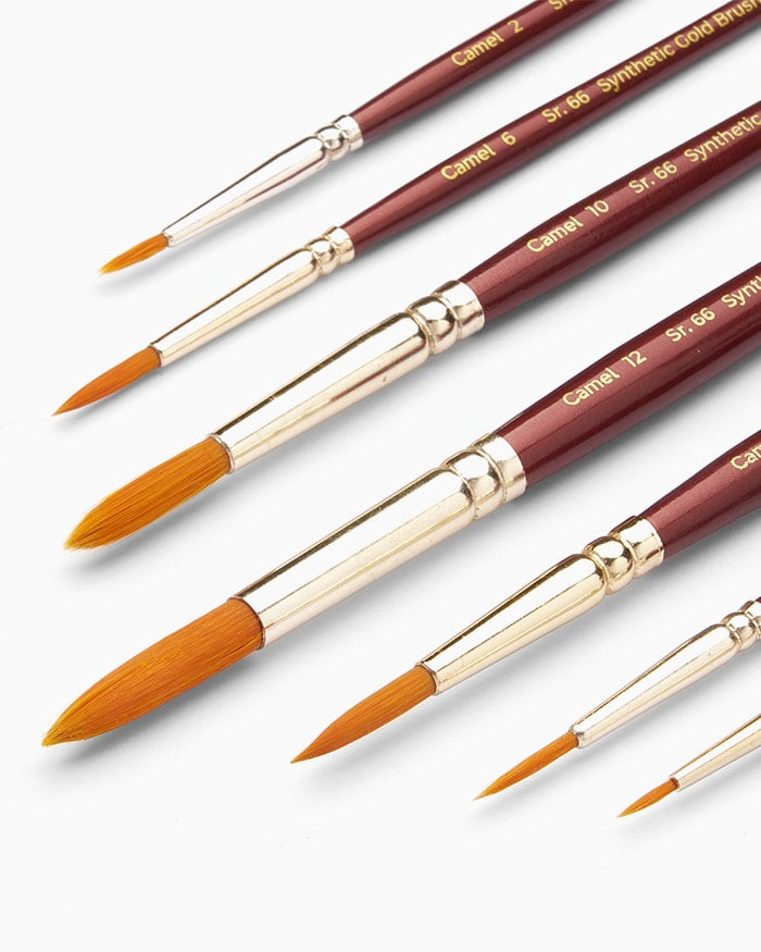 Set of Camel synthetic hair brushes with gold ferrules on a white background