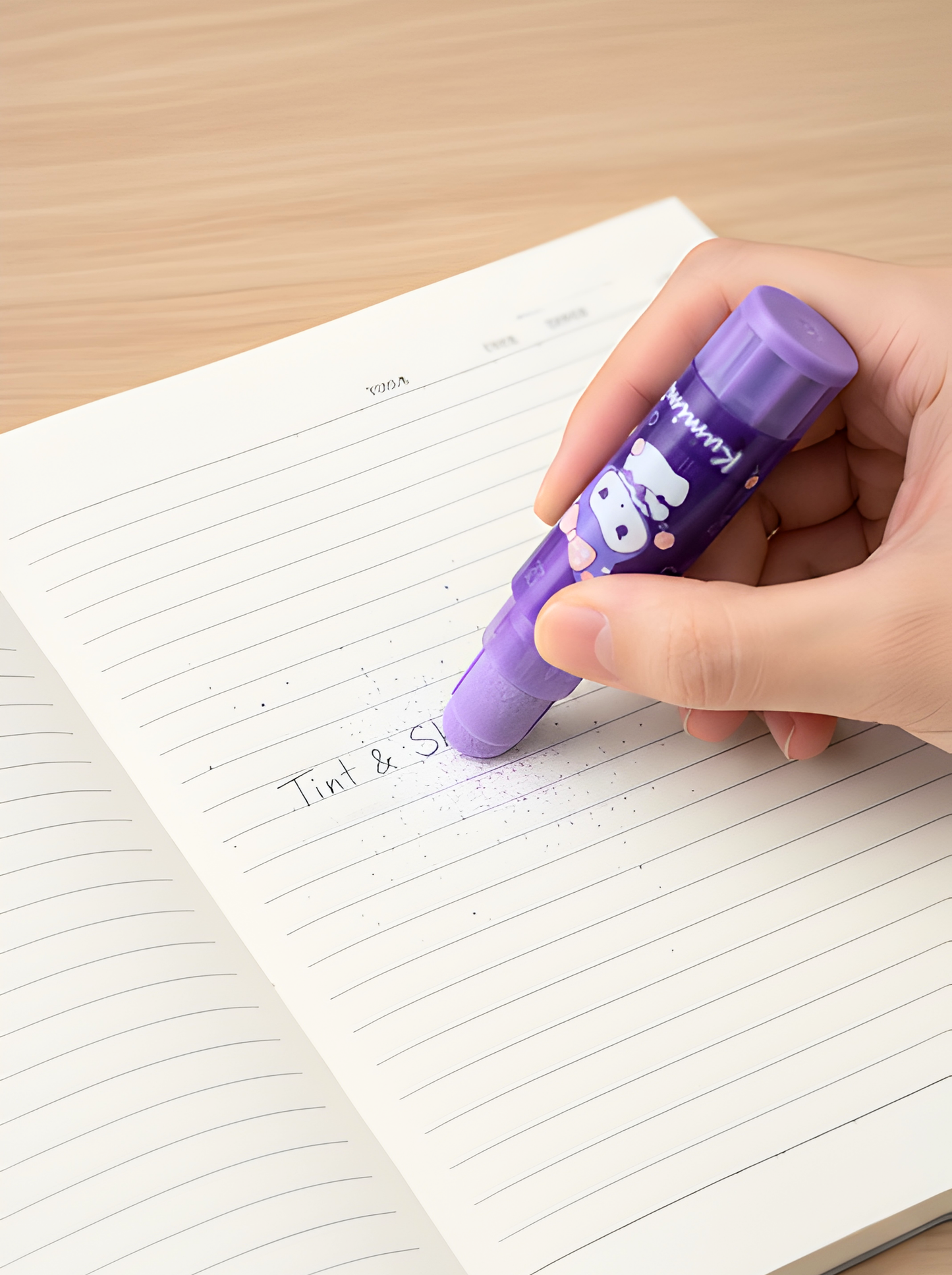 Hand holding a purple highlighter over a notebook with lined pages.