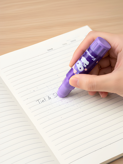 Hand holding a purple highlighter over a notebook with lined pages.
