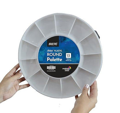 Round plastic art palette held by a person with a visible brand label on a white background