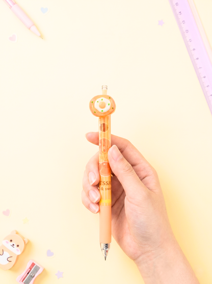 Hand holding a pen with a cute design on a light yellow background