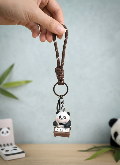 Keychain with panda design held by a hand against a light gray background