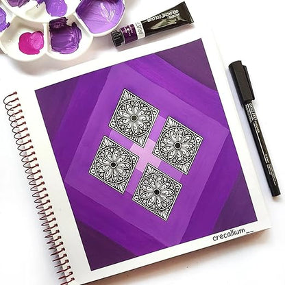 Purple notebook with black geometric designs, surrounded by art supplies on a white background