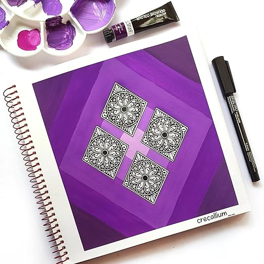 Purple notebook with black geometric designs, surrounded by art supplies on a white background