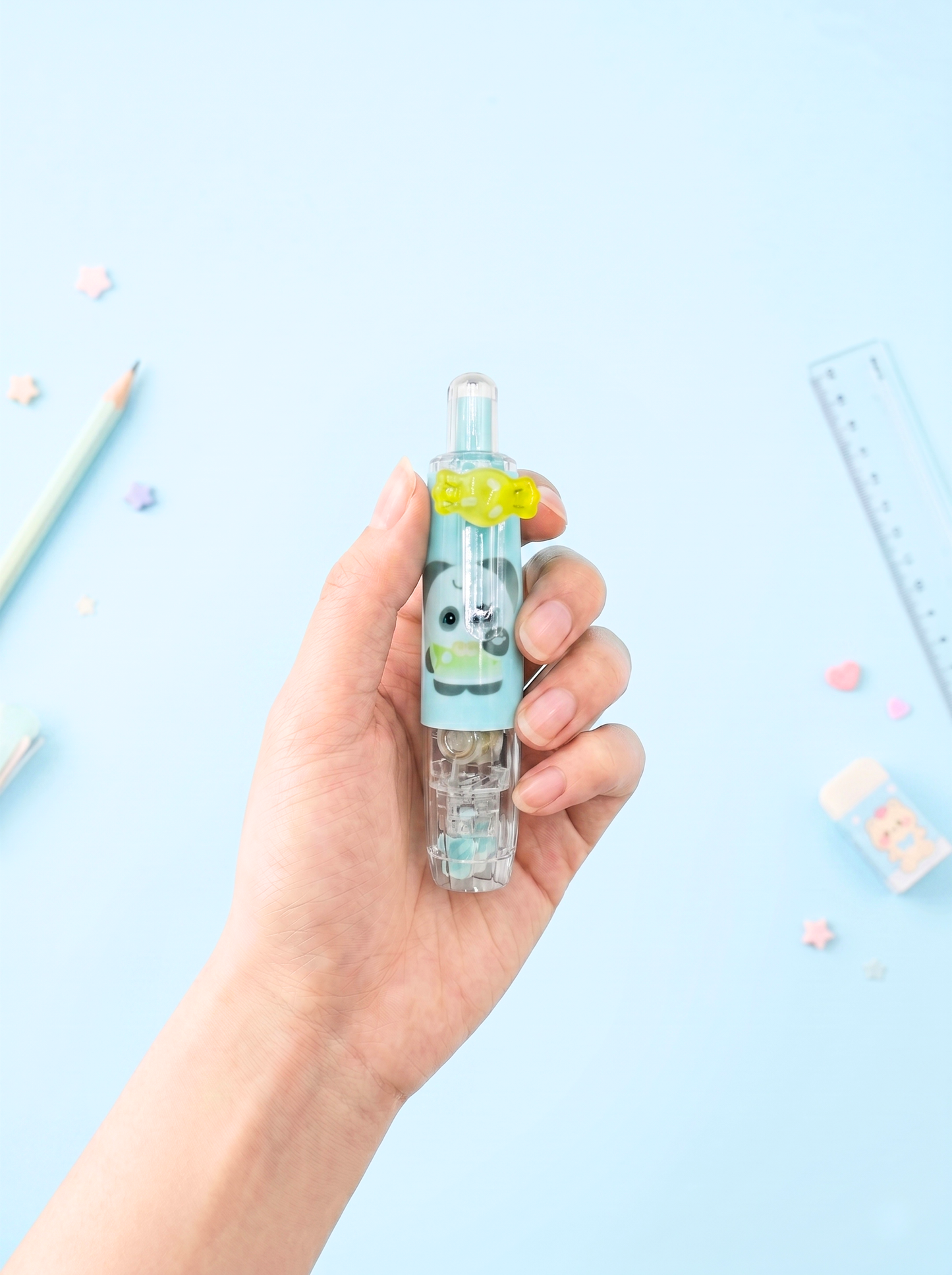 Hand holding a small bottle with a cartoon character on a light blue background