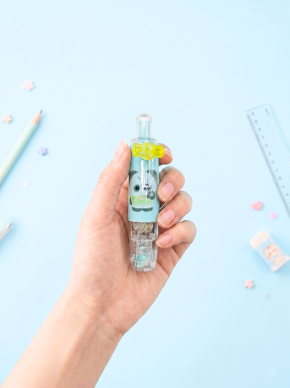 Hand holding a small bottle with a cartoon character on a light blue background