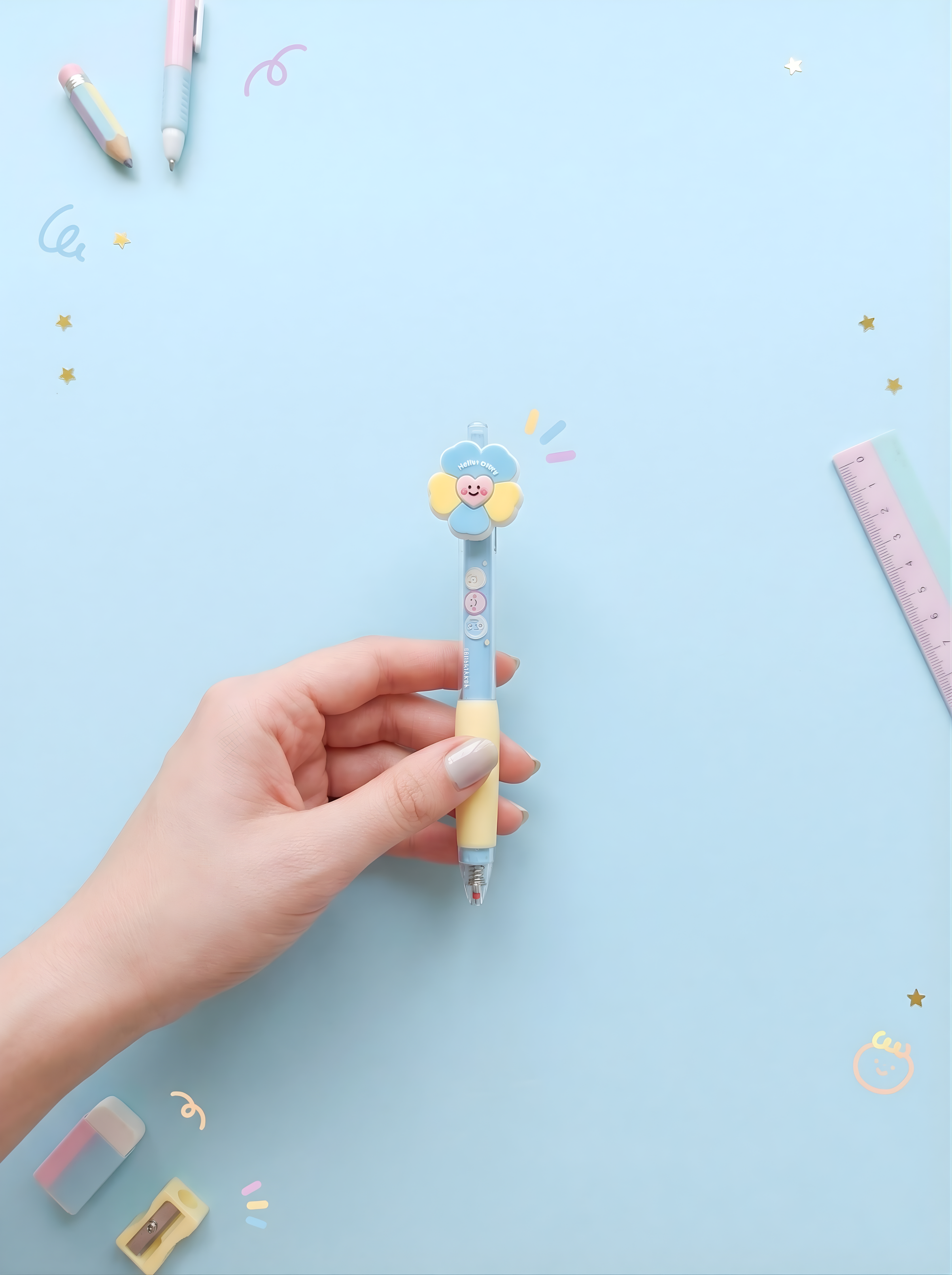 Hand holding a cute pen with a blue background and stationery items.