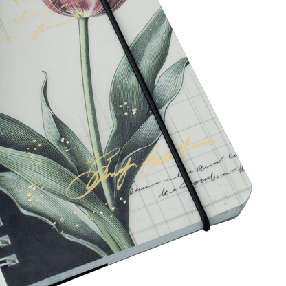 Notebook with floral design and black strap on a light gray background