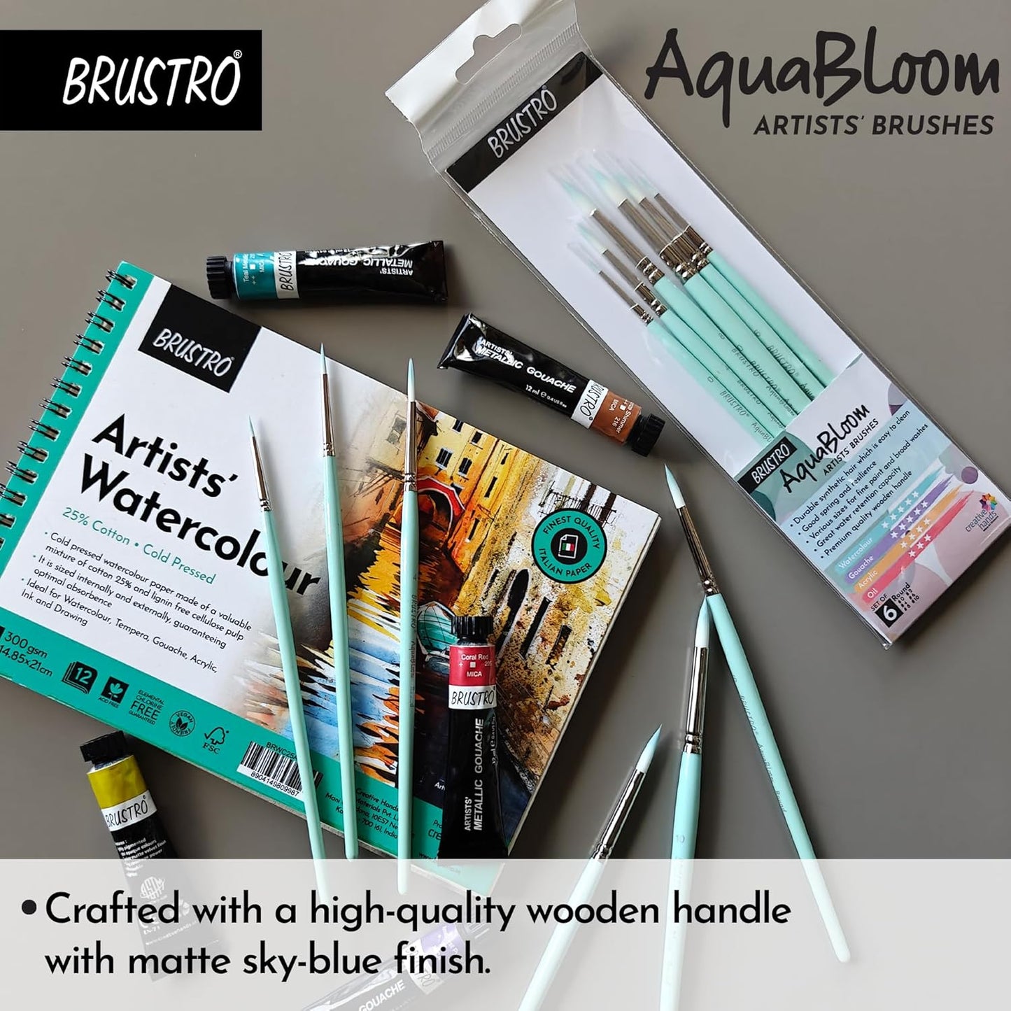Art supplies including a watercolor book, paint tubes, and brushes with BRUSTRO and AquaBloom branding.