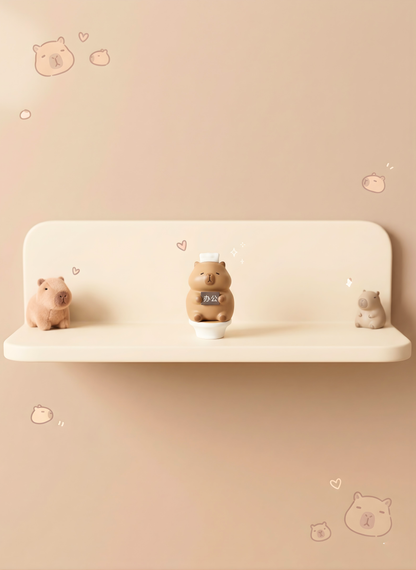 Three small animal figurines on a shelf against a beige wall with decorative elements.