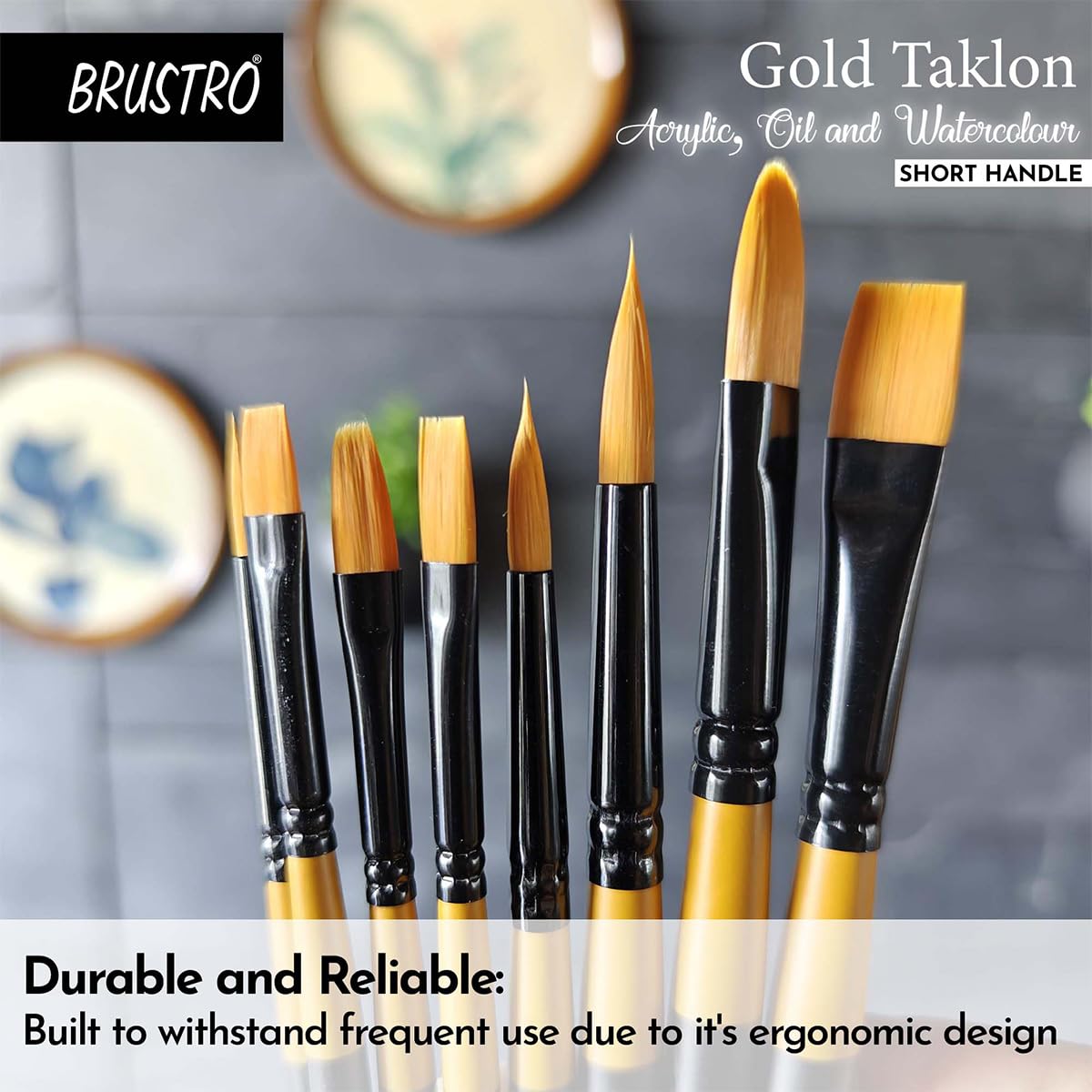 Set of BRUSTRO Gold Taklon paint brushes with a blurred painting background