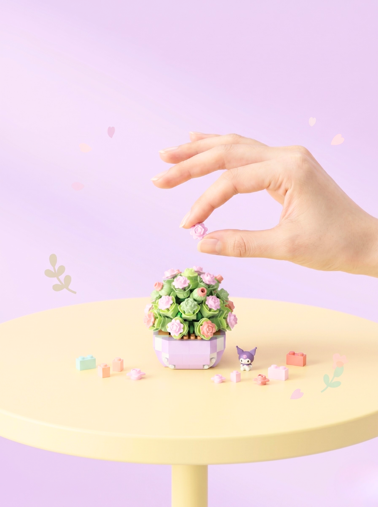 Small decorative plant on a yellow table with a hand reaching towards it against a light purple background