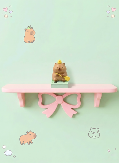 Small bear figurine on a pink shelf with a bow against a light green background