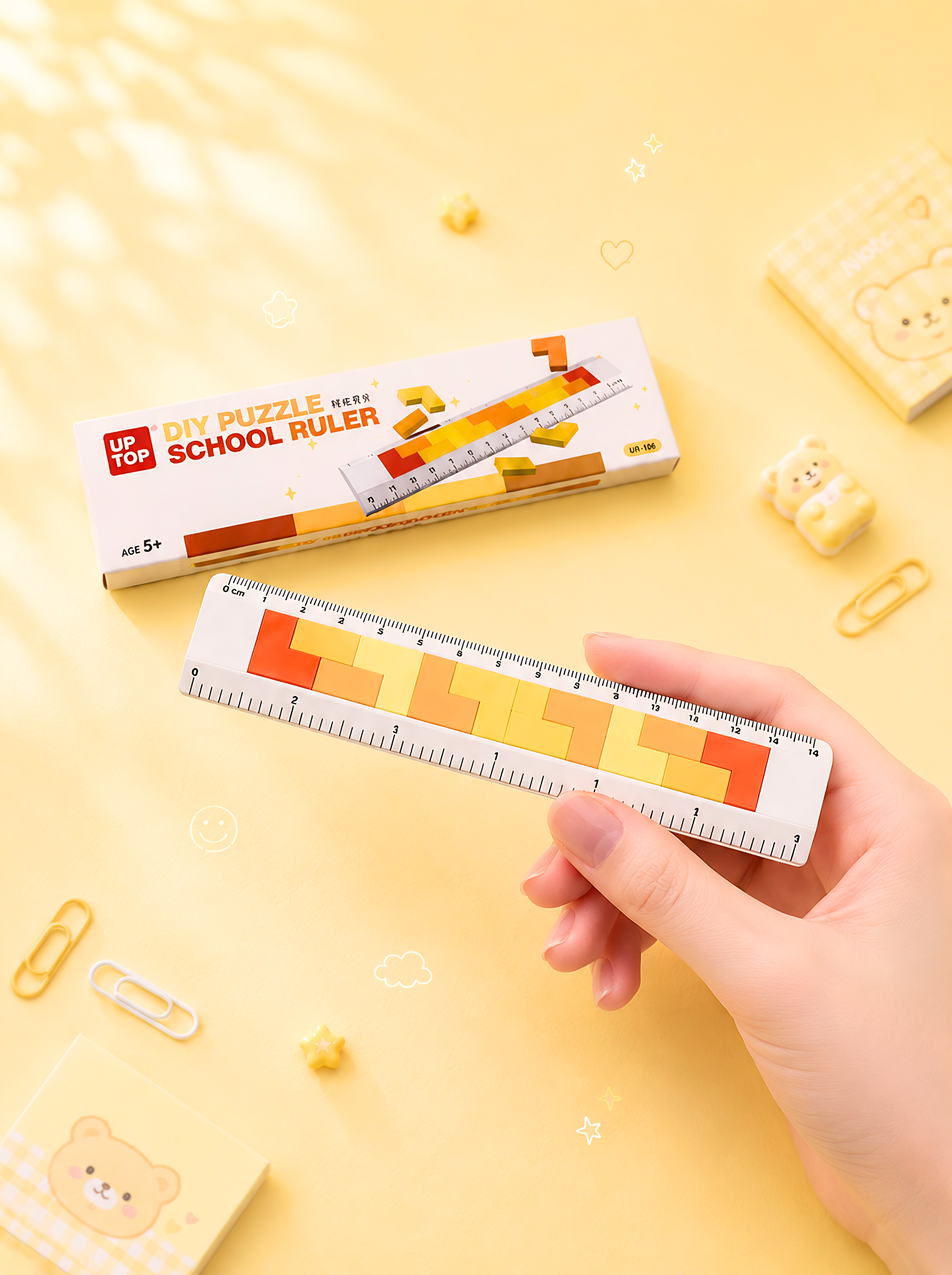 Hand holding a ruler with a colorful design on a yellow background