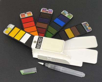 Set of watercolor pans with a brush on a dark background