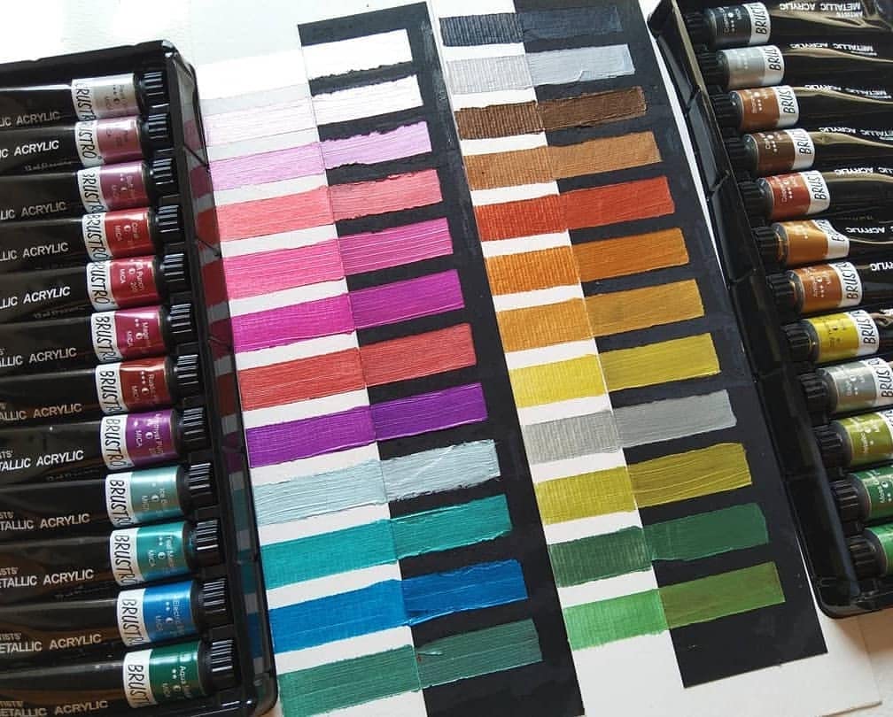 Set of acrylic paint tubes with color swatches on a white background
