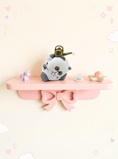 Decorative shelf with a panda figurine on a light pink background