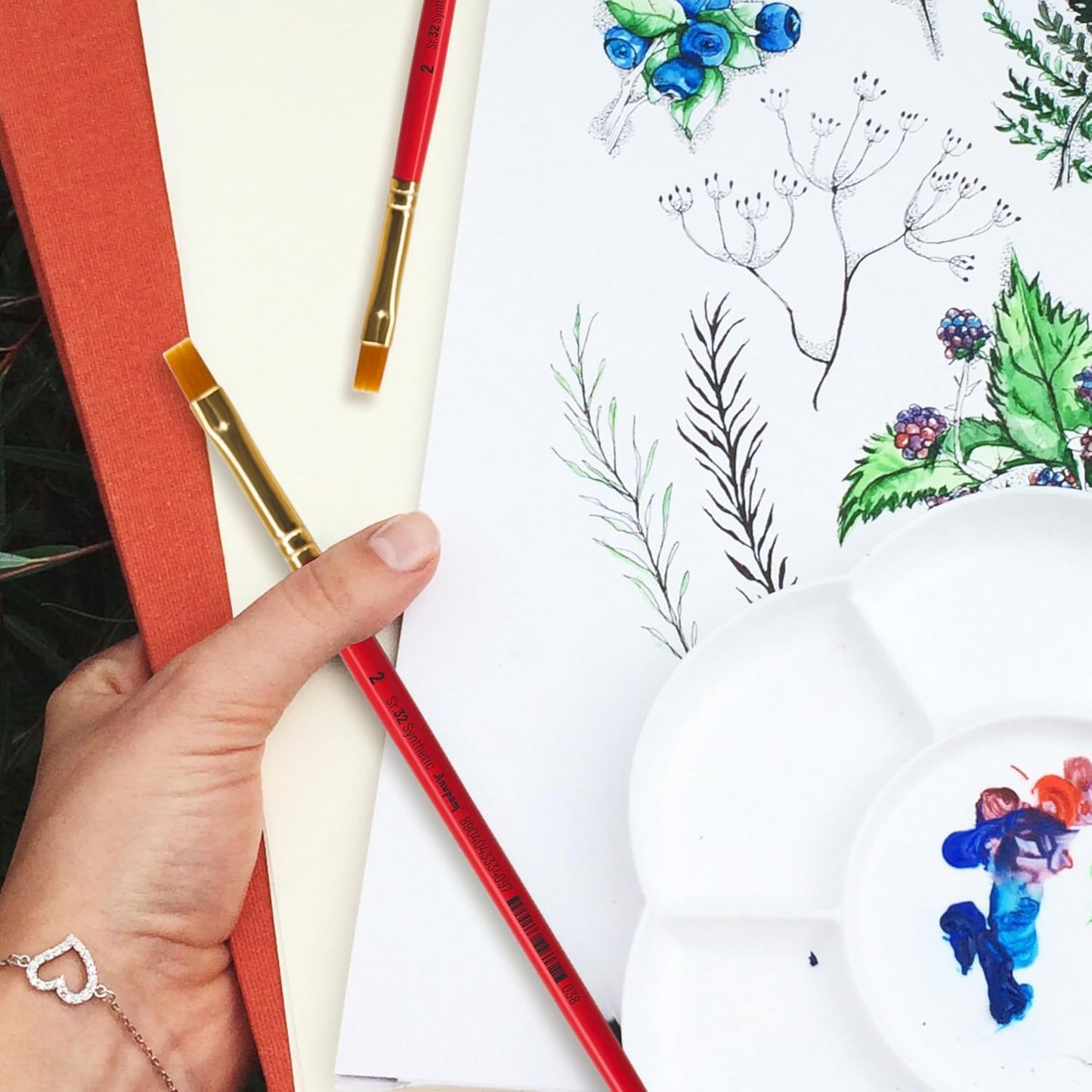 Artistic activity with colored pencils and a drawing of plants on a white surface.