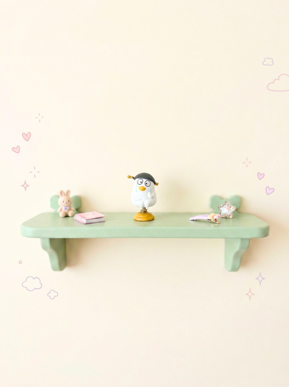 Light green shelf with decorative items on a light pink wall