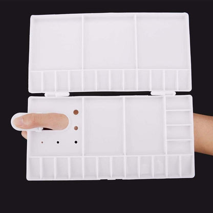 Clear plastic organizer with compartments held open by a hand on a black background