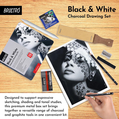 Brustro black and white charcoal drawing set on a wooden surface with a hand holding a pencil.