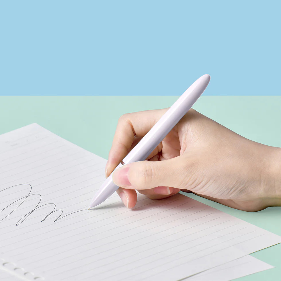 Hand holding a white pen writing on a piece of paper with a light blue background