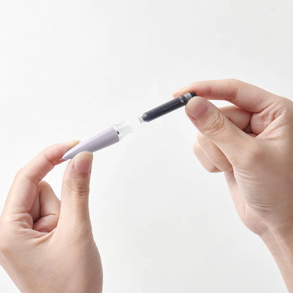 Two hands holding a pen with a white body and black cap against a light gray background