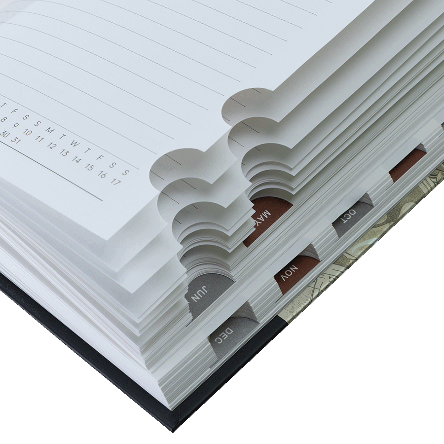 Close-up of a planner with monthly tabs and a calendar page.