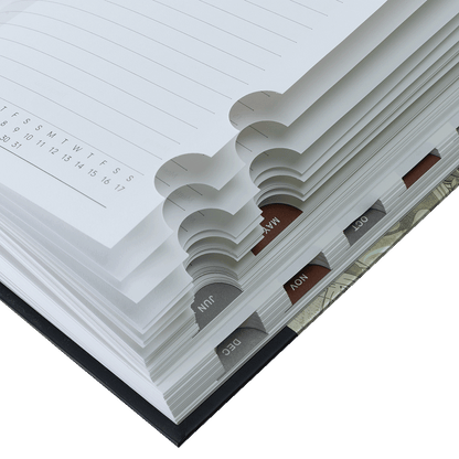 Close-up of a planner with monthly tabs and a calendar page.