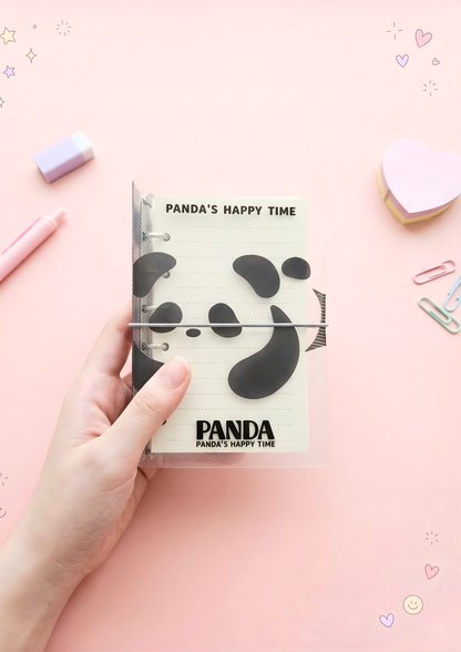 Notebook with panda design held by a hand on a pink background