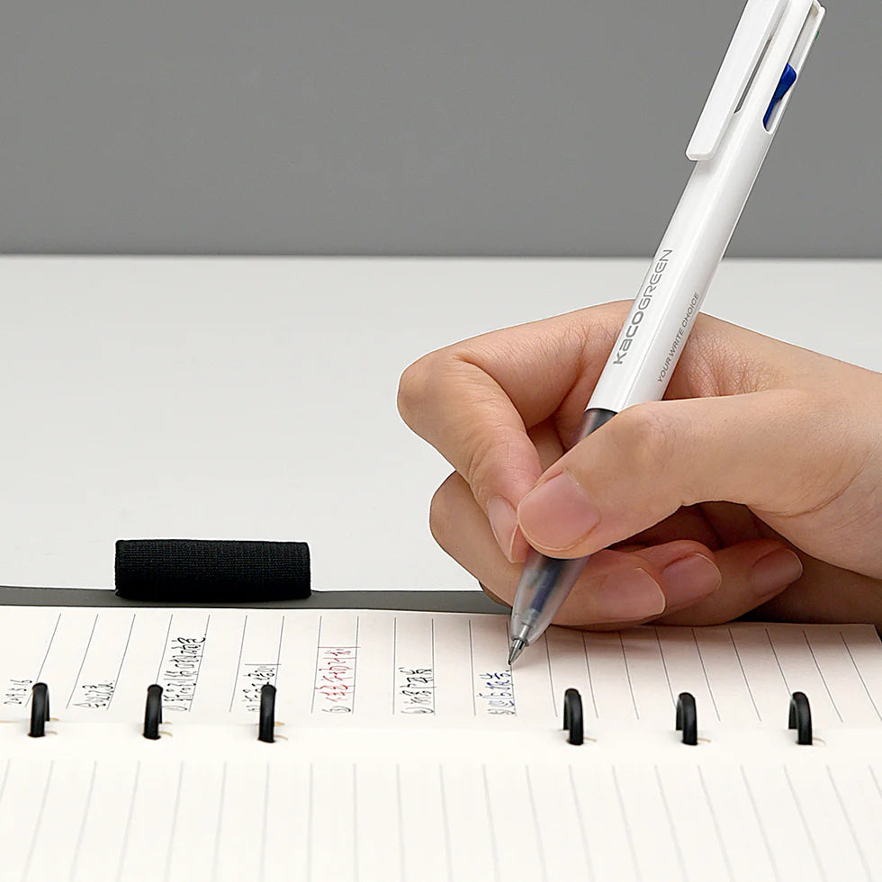 Hand holding a pen over a planner with a gray background