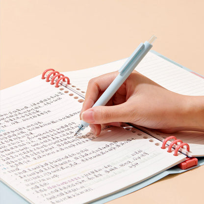 Hand writing in a notebook with a pen on a beige background