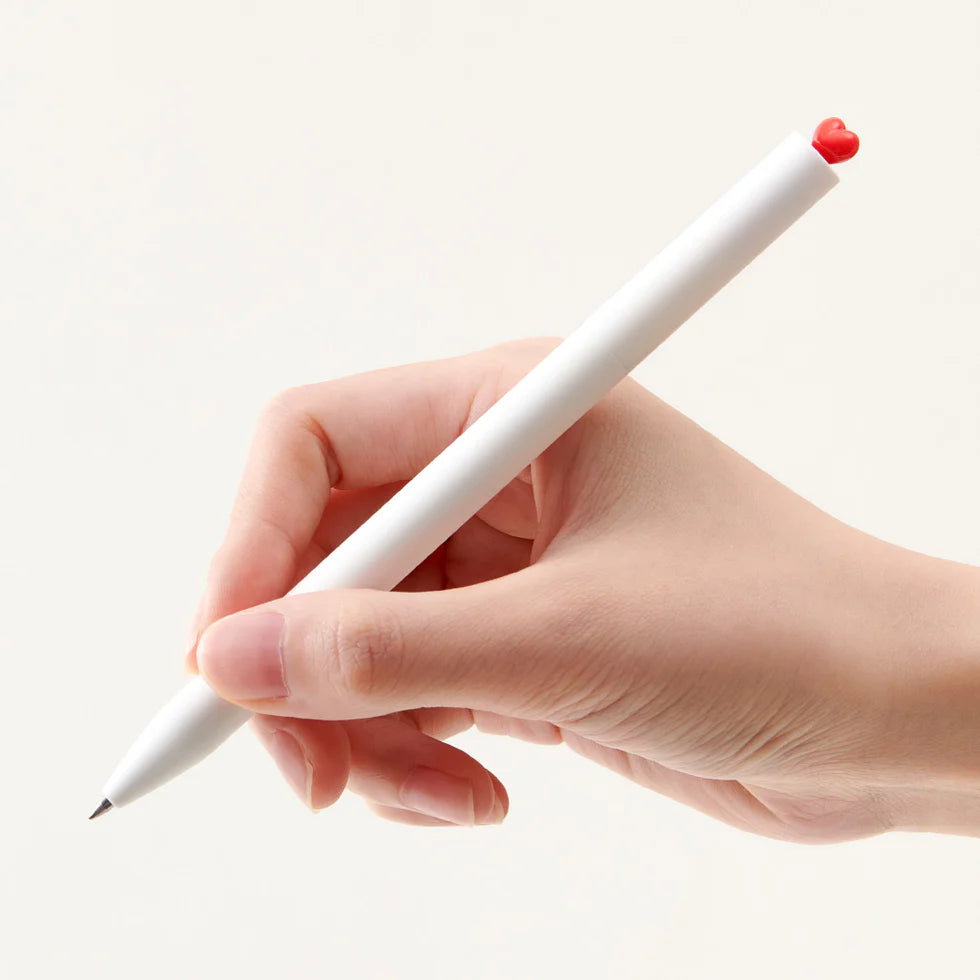 Hand holding a white pen with a red tip on a light beige background