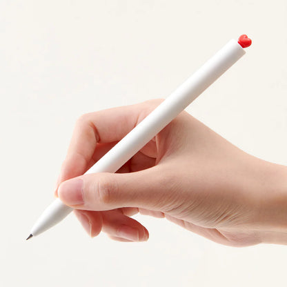Hand holding a white pen with a red tip on a light beige background