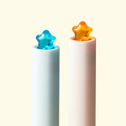 Two colorful star-shaped objects on white cylindrical stands against a light background