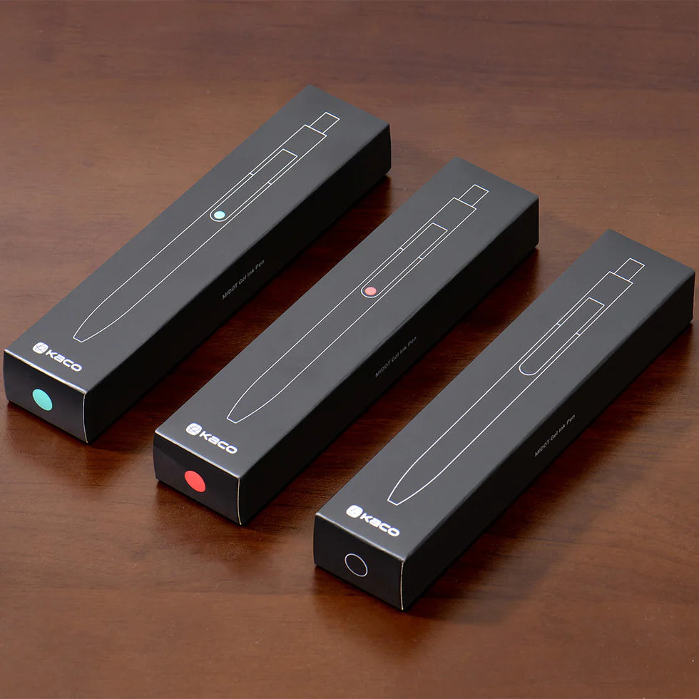 Three black Kaco pen boxes on a wooden surface