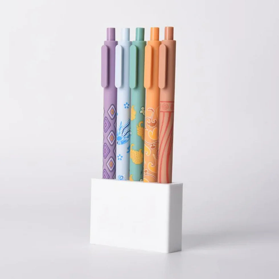 Five colorful pens in a holder on a light gray background