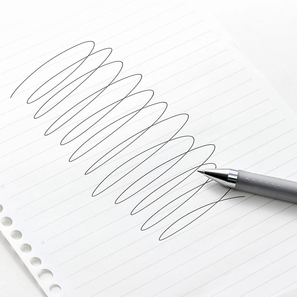 Pen writing on lined paper with a focus on the pen's tip and strokes.