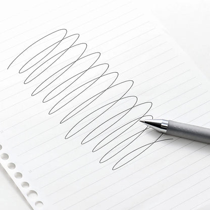 Pen writing on lined paper with a focus on the pen's tip and strokes.