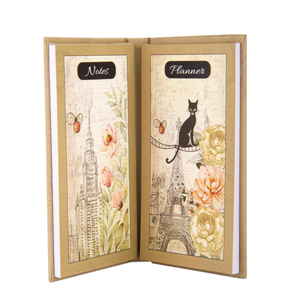 Open notebook with 'Notes' and 'Planner' labels, featuring cityscape and cat illustrations on a white background.