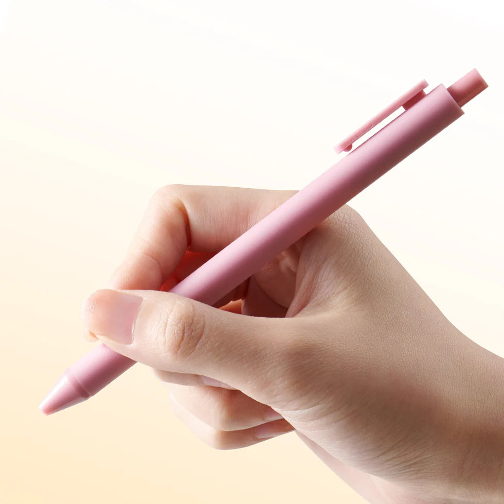Hand holding a pink pen against a light background