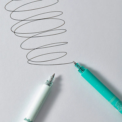 Two pens on a white background with one pen drawing a wavy line.