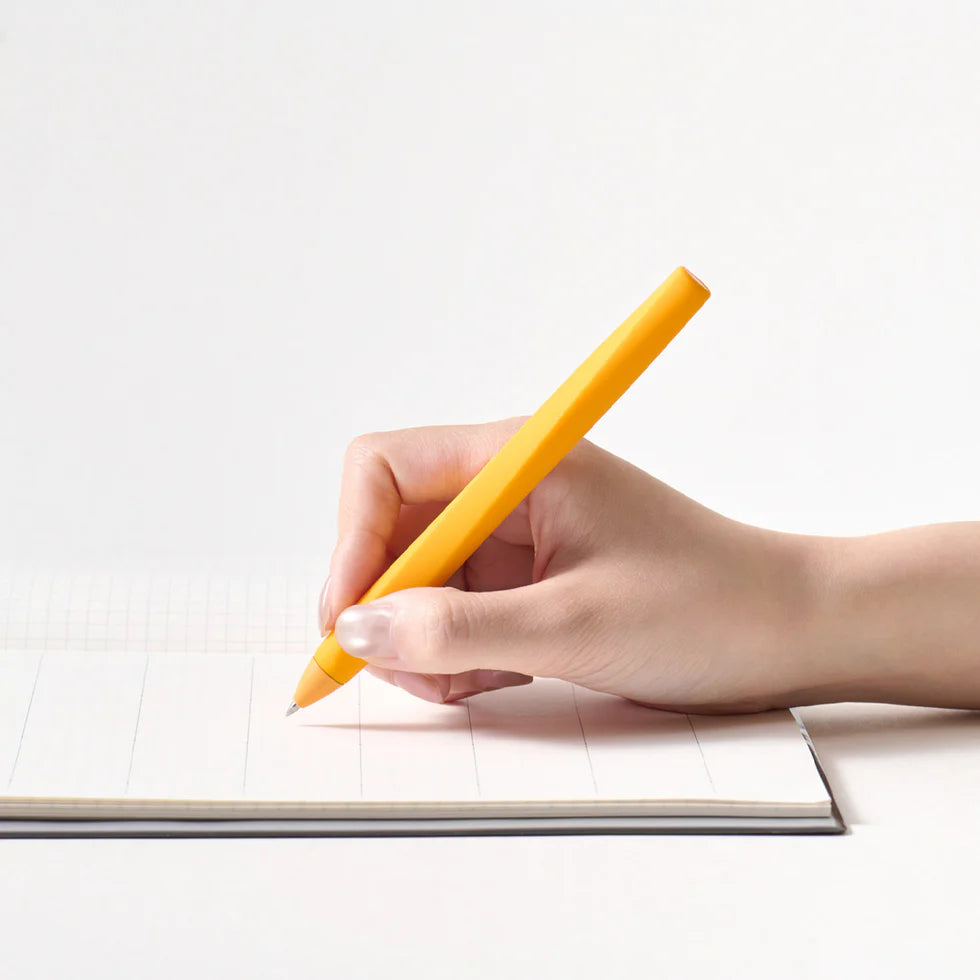 Hand holding a yellow pen over a notebook on a white background
