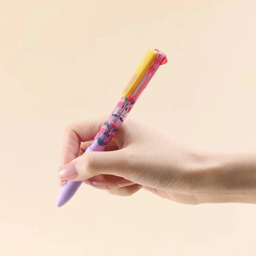 Hand holding a colorful pen against a beige background