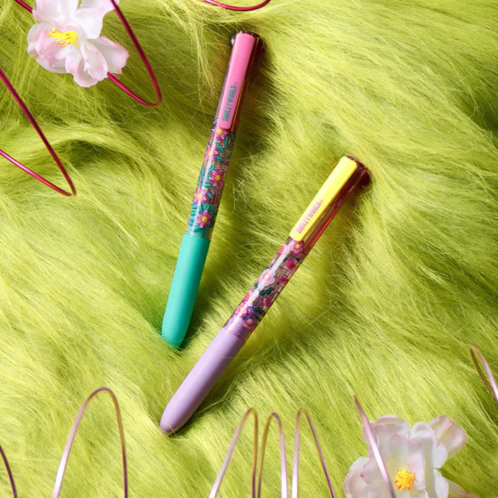 Two colorful pens on a green textured surface with decorative elements.